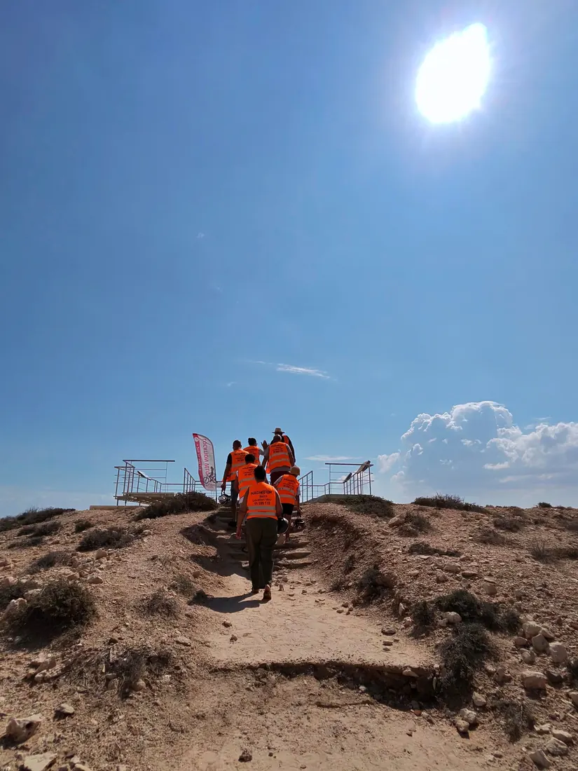 Le groupe en gilets orange monte vers le belvédère du site antique de Meninx