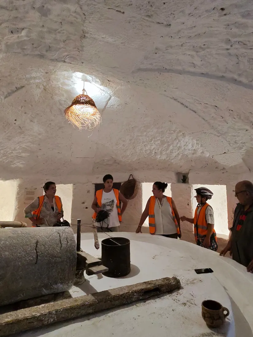 Le groupe autour de la meule d'un pressoir à huile souterrain
