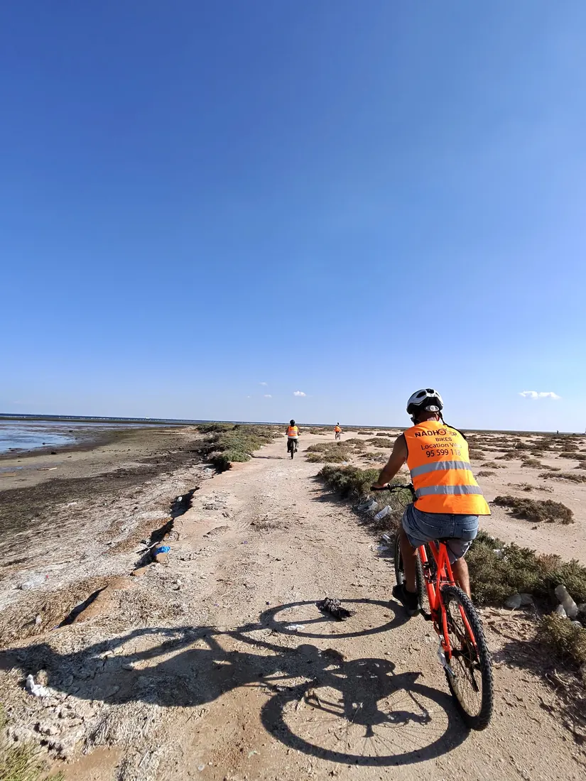 Des cyclistes sur une plage presque déserte